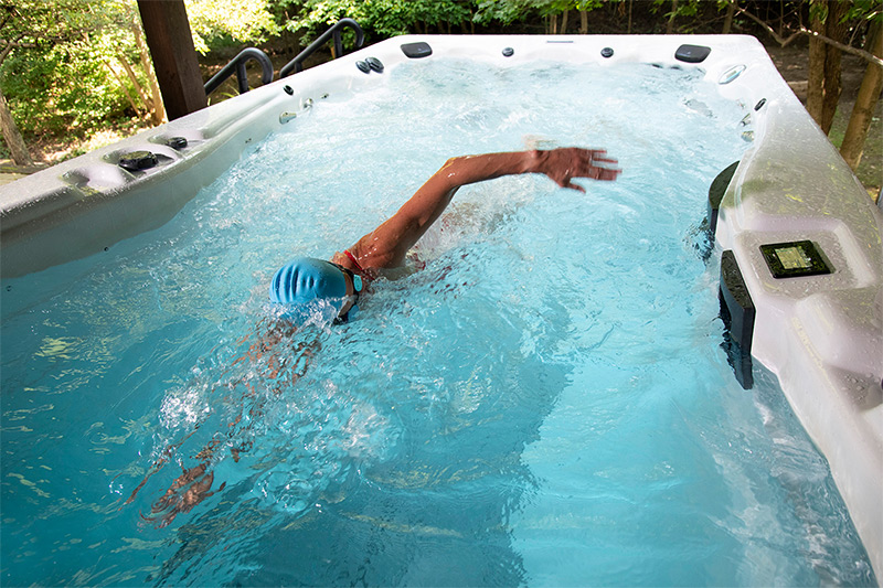 Meredith Kessler, IRONMAN&reg; champion, with an h2x swim spa by master spas